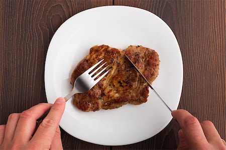 steak knife - Someone eating delicious grilled steak on a white plate Foto de stock - Super Valor sin royalties y Suscripción, Código: 400-07036577