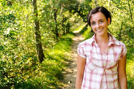 A smiling young Caucasian girl wearing mountain clothes on a hiking path in the wood Foto de stock - Super Valor sin royalties y Suscripción, Código: 400-07038703
