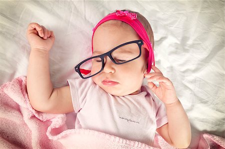 Funny sleepy baby with eyewear on her head Stockbilder - Microstock & Abonnement, Bildnummer: 400-07039966