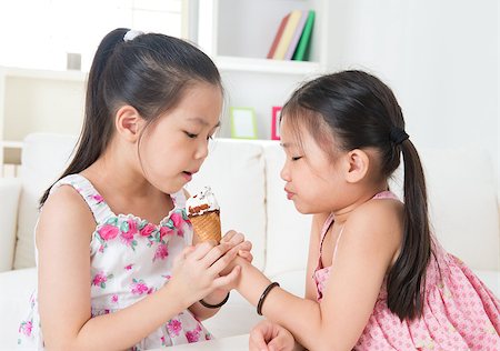 Eating ice cream cone. Asian girls sharing an ice cream. Beautiful children model at home. Stock Photo - Budget Royalty-Free & Subscription, Code: 400-07046767