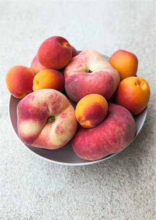 simsearch:400-07667203,k - Assorted colorful fresh summer fruits - apricots and donut peaches in the bowl on stone table Stock Photo - Budget Royalty-Free & Subscription, Code: 400-07047085