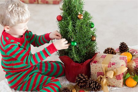 decorating small xmas tree - cute caucasian boy decorating a christmas tree at winter time Stock Photo - Budget Royalty-Free & Subscription, Code: 400-07047132