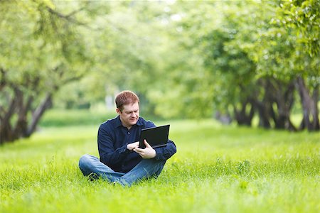 Middle-aged businessman working with notebook in the park. Stock Photo - Budget Royalty-Free & Subscription, Code: 400-07047420