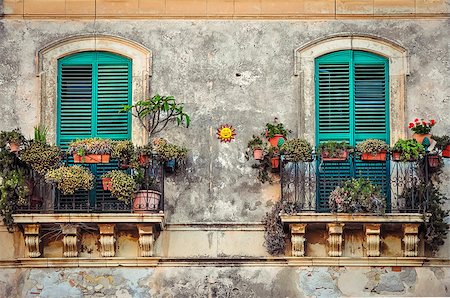 Beautiful vintage balcony with colorful flowers and wooden doors, Mediterranean style Stock Photo - Budget Royalty-Free & Subscription, Code: 400-07048172