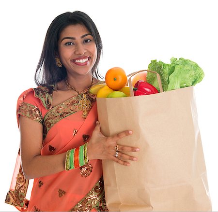Happy grocery shopper. Portrait of beautiful traditional Indian woman in sari dress holding paper shopping bag full of groceries isolated on white. Stock Photo - Budget Royalty-Free & Subscription, Code: 400-07048901