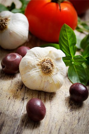 simsearch:400-04598775,k - Food ingredinets. Garlic, olives, tomato and basil on wooden table. Photographie de stock - Aubaine LD & Abonnement, Code: 400-07049878