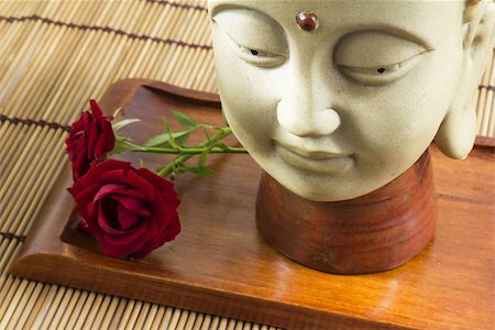 simsearch:400-05099216,k - A buddha head with two roses, laid on a mat of sticks Stock Photo - Budget Royalty-Free & Subscription, Code: 400-07043956