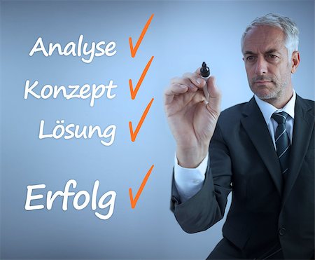 Attractive businessman writing a success checklist in german on grey background Foto de stock - Super Valor sin royalties y Suscripción, Código: 400-07056898