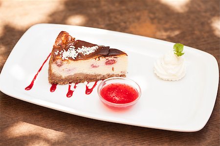 Cheesecake with chantilly cream and coulis served in bright terrace Stock Photo - Budget Royalty-Free & Subscription, Code: 400-07057176