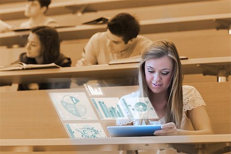 simsearch:400-07057823,k - Pretty blonde student analysing graphs on her digital tablet in lecture hall Foto de stock - Super Valor sin royalties y Suscripción, Código: 400-07057292