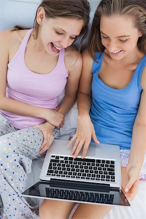 Girls sitting on bed using laptop and talking at sleepover Stock Photo - Budget Royalty-Free & Subscription, Code: 400-07057437