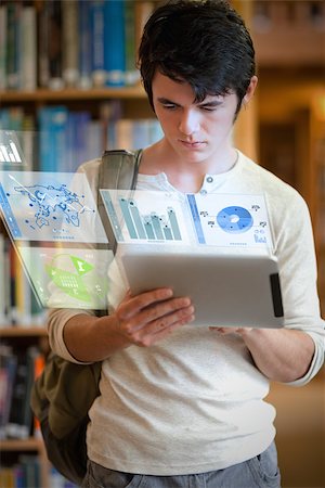 simsearch:400-07138128,k - Serious handsome student working on his futuristic tablet pc in university library Stock Photo - Budget Royalty-Free & Subscription, Code: 400-07057826