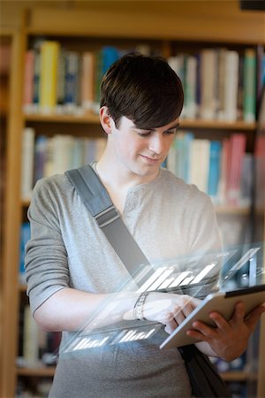 simsearch:400-07057823,k - Serious student analysing graphs on his digital tablet in university library Foto de stock - Super Valor sin royalties y Suscripción, Código: 400-07057841