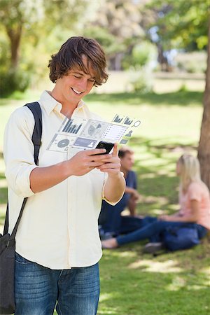 Cheerful student working on his digital smartphone in bright park Stock Photo - Budget Royalty-Free & Subscription, Code: 400-07057875