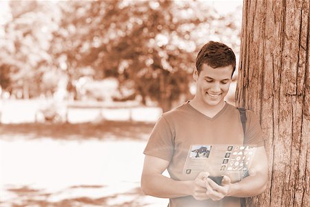 simsearch:400-07057823,k - Cheerful handsome student using his digital phone in bright park Foto de stock - Super Valor sin royalties y Suscripción, Código: 400-07057882