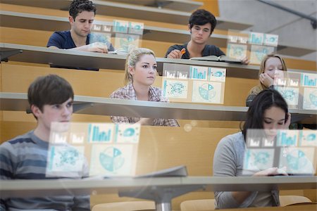 simsearch:400-07138128,k - Focused students in lecture hall working on their futuristic tablet during lesson Stock Photo - Budget Royalty-Free & Subscription, Code: 400-07057935