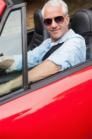 simsearch:400-07057982,k - Cheerful handsome man driving his red convertible on a bright day Foto de stock - Super Valor sin royalties y Suscripción, Código: 400-07057969