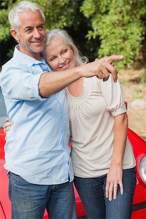 simsearch:400-07057982,k - Smiling mature couple posing by their red convertible on bright day Foto de stock - Super Valor sin royalties y Suscripción, Código: 400-07058005