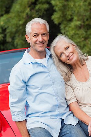 simsearch:400-07057982,k - Cheerful mature couple sitting on their red convertible on bright day Foto de stock - Super Valor sin royalties y Suscripción, Código: 400-07058007