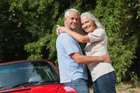 simsearch:400-07057982,k - Smiling mature couple hugging against their red cabriolet on a sunny day Foto de stock - Super Valor sin royalties y Suscripción, Código: 400-07058028