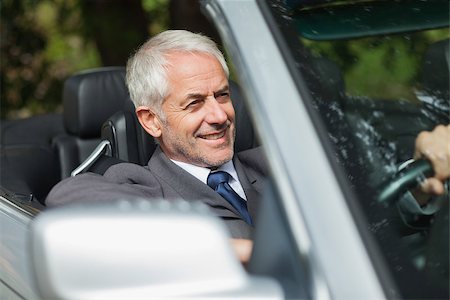 simsearch:693-05552680,k - Smiling businessman driving expensive cabriolet on sunny day Stock Photo - Budget Royalty-Free & Subscription, Code: 400-07058055