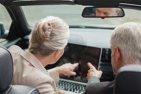simsearch:693-05552680,k - Business people working together on laptop in classy cabriolet on a bright day Stock Photo - Budget Royalty-Free & Subscription, Code: 400-07058075
