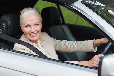 Cheerful businesswoman driving classy car on a bright day Stock Photo - Budget Royalty-Free & Subscription, Code: 400-07058070