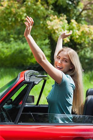 simsearch:400-07058112,k - Smiling blonde enjoying her red cabriolet on a sunny day Photographie de stock - Aubaine LD & Abonnement, Code: 400-07058105