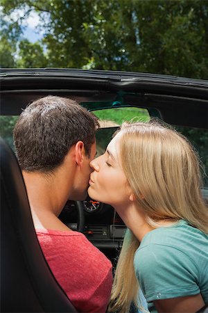 simsearch:400-07058112,k - Attractive blonde kissing her boyfriend while having a ride in cabriolet on a sunny day Photographie de stock - Aubaine LD & Abonnement, Code: 400-07058116