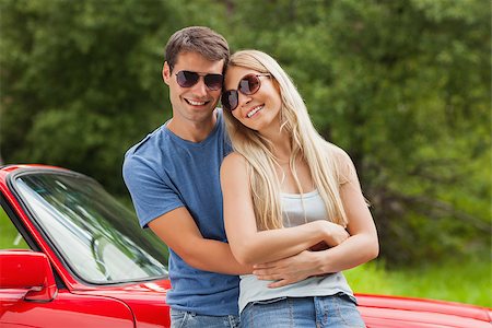 simsearch:400-07058112,k - Cheerful couple hugging and leaning against cabriolet on a sunny day Photographie de stock - Aubaine LD & Abonnement, Code: 400-07058156