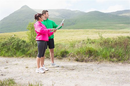 people on trail with map - Athletic couple holding a map and looking ahead in the countryside Stock Photo - Budget Royalty-Free & Subscription, Code: 400-07058447