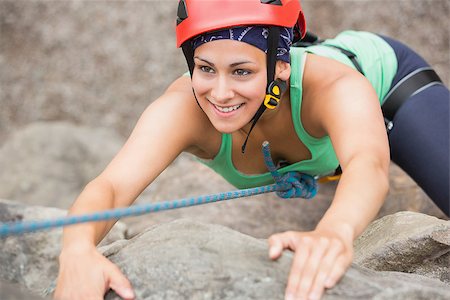 simsearch:400-06956627,k - Happy girl climbing rock face wearing red helmet Stock Photo - Budget Royalty-Free & Subscription, Code: 400-07058536