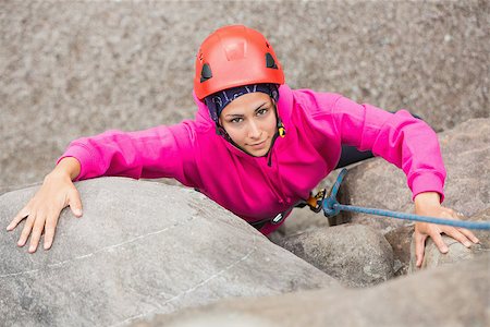 simsearch:400-06956627,k - Smiling girl climbing up rock face looking at camera Stock Photo - Budget Royalty-Free & Subscription, Code: 400-07058539