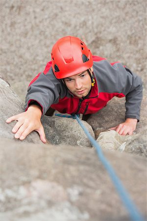simsearch:400-06956627,k - Focused man climbing rock face wearing red helmet Stock Photo - Budget Royalty-Free & Subscription, Code: 400-07058544