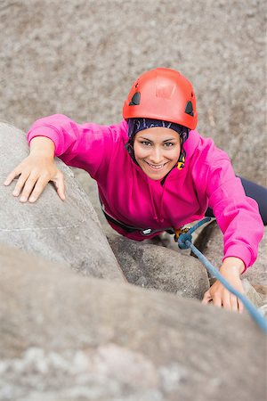 simsearch:400-06956627,k - Happy girl climbing up rock face looking at camera Stock Photo - Budget Royalty-Free & Subscription, Code: 400-07058540