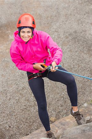 simsearch:400-06956627,k - Happy girl abseiling down rock face looking up at camera Stock Photo - Budget Royalty-Free & Subscription, Code: 400-07058542