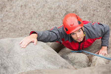 simsearch:400-06956627,k - Determined man climbing rock face wearing red helmet Stock Photo - Budget Royalty-Free & Subscription, Code: 400-07058543