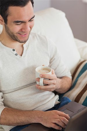 simsearch:6109-08581996,k - Calm attractive man drinking coffee while using his laptop in bright living room Fotografie stock - Microstock e Abbonamento, Codice: 400-07058745