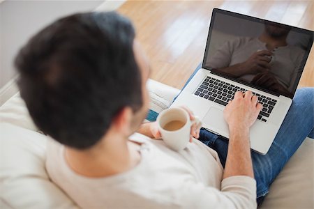 simsearch:6109-08581996,k - High angle view of young man using his laptop in bright living room Fotografie stock - Microstock e Abbonamento, Codice: 400-07058755