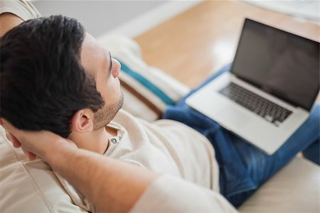 simsearch:6109-08581996,k - High angle view of relaxed young man using his laptop in bright living room Fotografie stock - Microstock e Abbonamento, Codice: 400-07058757