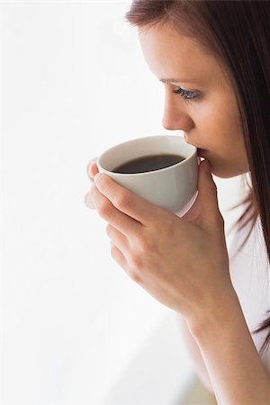 simsearch:400-06932687,k - Thoughtful teen holding a cup of coffee and looking away on white background Stock Photo - Budget Royalty-Free & Subscription, Code: 400-07059115