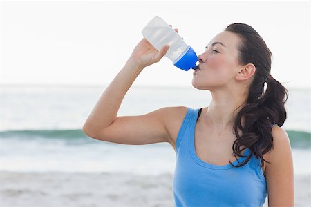 Brunette woman drinking after exercising in front of ocean at the beach Stock Photo - Budget Royalty-Free & Subscription, Code: 400-07059161