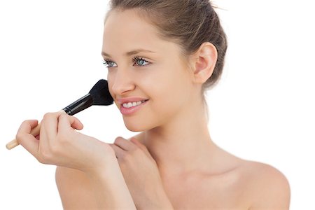 Pleased brunette model applying powder on her cheek on white background Stock Photo - Budget Royalty-Free & Subscription, Code: 400-07059589