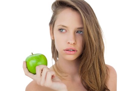 Wondering brunette model holding an apple on white background Stock Photo - Budget Royalty-Free & Subscription, Code: 400-07059688