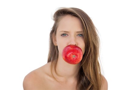 Pretty brunette model holding an apple in her mouth on white background Stock Photo - Budget Royalty-Free & Subscription, Code: 400-07059694