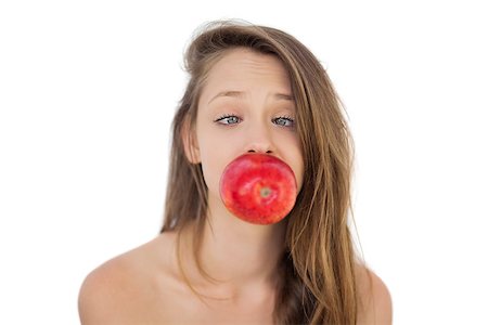 Concentrated brunette model holding an apple in her mouth on white background Stock Photo - Budget Royalty-Free & Subscription, Code: 400-07059696