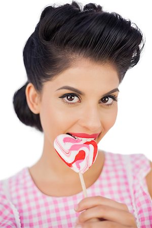 simsearch:6109-06781862,k - Cheerful black hair model chewing a heart shaped lollipop on white background Stock Photo - Budget Royalty-Free & Subscription, Code: 400-07059837