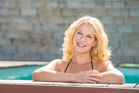 Portrait of a happy blond girl with blue eyes in a pool at the edge Stock Photo - Budget Royalty-Free & Subscription, Code: 400-07053533