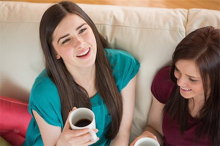simsearch:400-07059986,k - Two laughing friends having coffee on the couch at home in the living room Stock Photo - Budget Royalty-Free & Subscription, Code: 400-07060014