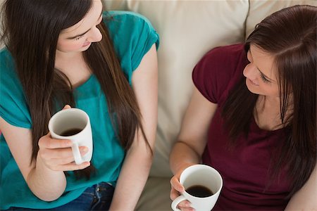simsearch:400-07059986,k - Two smiling friends having coffee and chatting on the couch at home in the living room Stock Photo - Budget Royalty-Free & Subscription, Code: 400-07060013